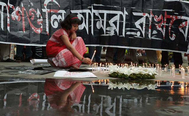 people light candles at a memorial for the victims of dhaka attack photo afp