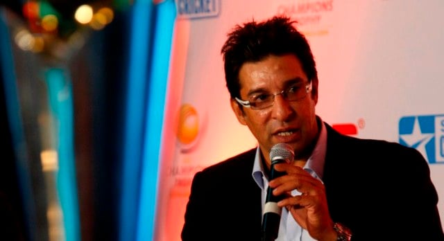 former pakistani cricketer wasim akram talks about the upcoming icc champions trophy in new delhi india thursday sept 17 2009 on the left is the trophy that will be handed out to the winner photo afp