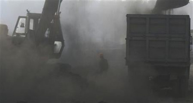 a man is shrouded in coal dust as a bulldozer loads coal onto a truck at a railway yard photo reuters a man is shrouded in coal dust as a bulldozer loads coal onto a truck at a railway yard photo reuters