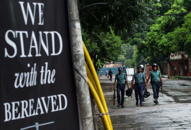 a sign of solidarity is placed near the restaurant where a bloody siege ended in the death of seventeen foreigners and five bangladeshis in dhaka on july 5 2016 photo afp