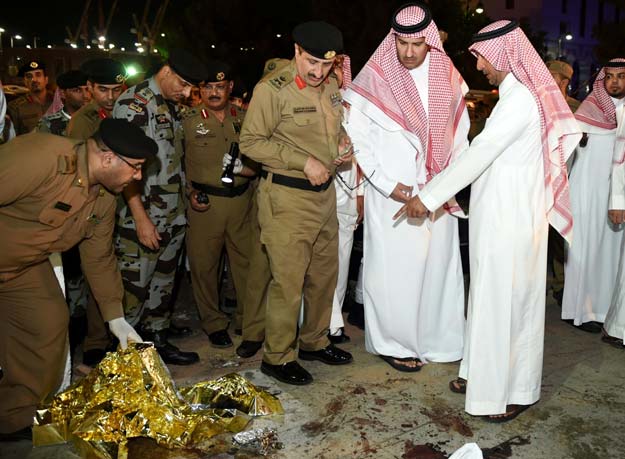 this file photo taken on july 4 2016 shows saudi emir of madina faisal bin salman bin abdulaziz 2r and security officers looking at blood stains on the ground after a suicide attack near the security headquarters outside the prophet pbuh 039 s mosque in madina photo afp