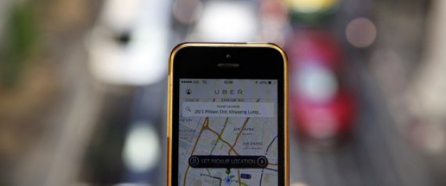a phone running the uber application is held above the traffic in central bangkok december 10 2014 photo reuters a phone running the uber application is held above the traffic in central bangkok december 10 2014 photo reuters