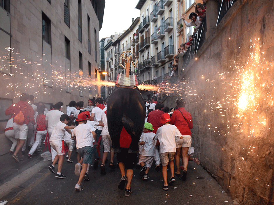 a man incarnating a quot toro de fuego quot bull of fire chases people during the san fermin festival in pamplona northern spain photo afp