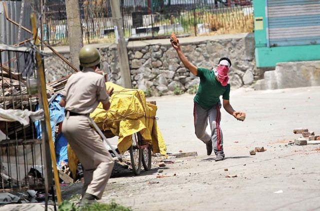 a protester throws a brick at a policeman during clashes in indian kashmir photo inp