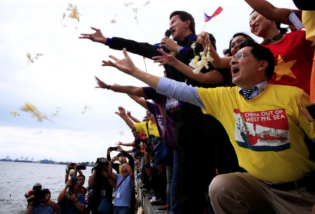 protesters throws flowers while chanting anti chinese slogans during a rally by different activist groups over the south china sea disputes along a bay in metro manila philippines july 12 2016 photo reuters