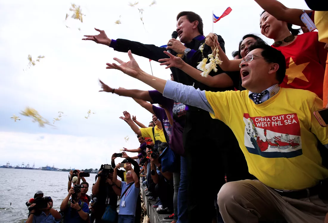 protesters throws flowers while chanting anti chinese slogans during a rally by different activist groups over the south china sea disputes along a bay in metro manila philippines july 12 2016 photo reuters protesters throws flowers while chanting anti chinese slogans during a rally by different activist groups over the south china sea disputes along a bay in metro manila philippines july 12 2016 photo reuters