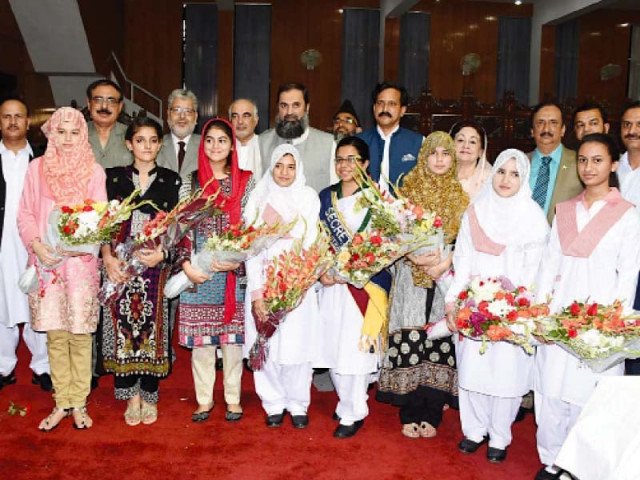 state minister balighur rehman is seen being photographed with position holders during a high achievers ceremony for matric students photo waseem nazir express