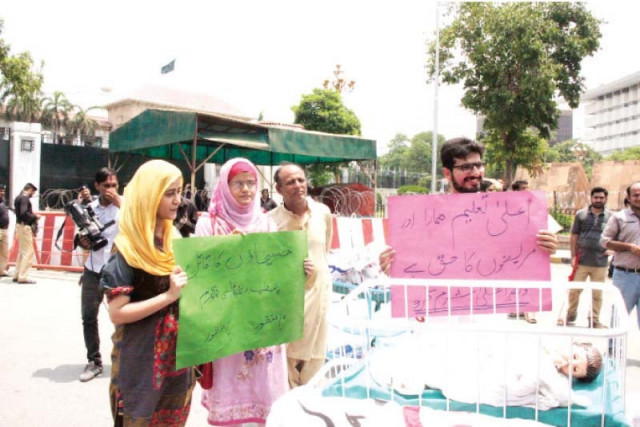 members of the yda in dera ghazi khan at the demonstration on jampur road left doctors holding placards next to a cradle and a doll on the mall lahore photos express