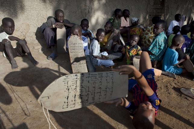 boys recite quranic verses handwritten on pieces of wood during a religious class in front of the grand mosque of djenne mali september 1 2012 photo reuters