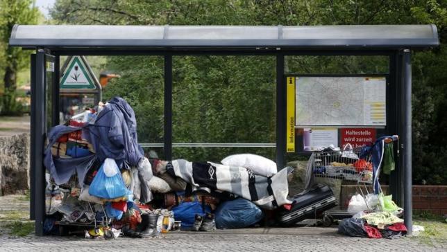 a homeless man sleeps amongst his possessions inside a bus stop at berlin 039 s kreuzberg district april 8 2014 photo reuters