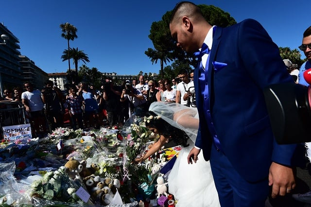a newly wed couple places flowers at a makeshift memorial on the pavement at the promenade des anglais in nice on july 16 2016 in tribute to the victims of the deadly bastille day attack photo afp a newly wed couple places flowers at a makeshift memorial on the pavement at the promenade des anglais in nice on july 16 2016 in tribute to the victims of the deadly bastille day attack photo afp