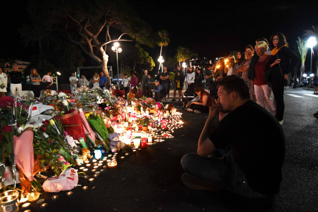 a man reacts as he sits before a make shift memorial placed on the road for victims of the deadly bastille day attack on july 17 2016 in nice photo afp a man reacts as he sits before a make shift memorial placed on the road for victims of the deadly bastille day attack on july 17 2016 in nice photo afp