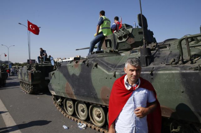 a man wrapped in a turkish flag stands next to military vehicles in front of sabiha airport in istanbul turkey photo reuters a man wrapped in a turkish flag stands next to military vehicles in front of sabiha airport in istanbul turkey photo reuters