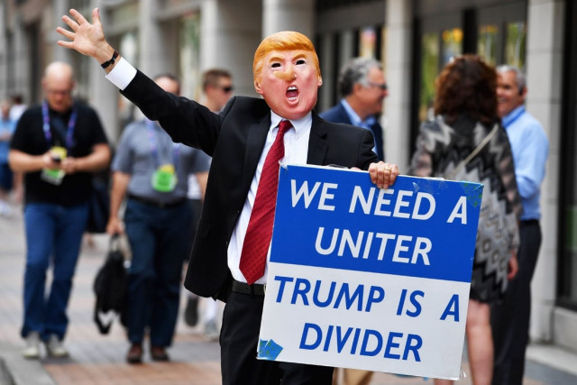 a man wearing a mask of donald trump walks through downtown ahead of the upcoming republican national convention on july 17 2016 in cleveland ohio photo afp a man wearing a mask of donald trump walks through downtown ahead of the upcoming republican national convention on july 17 2016 in cleveland ohio photo afp
