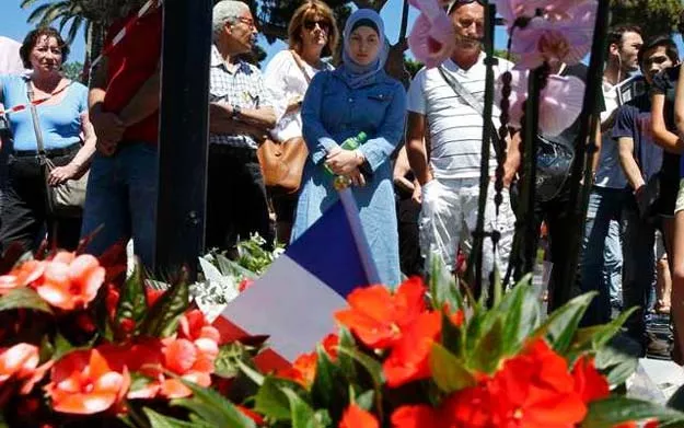 people stand near flowers as they pay tribute near the scene where a truck ran into a crowd at high speed killing scores and injuring more who were celebrating the bastille day national holiday in nice france july 15 2016 photo reuters people stand near flowers as they pay tribute near the scene where a truck ran into a crowd at high speed killing scores and injuring more who were celebrating the bastille day national holiday in nice france july 15 2016 photo reuters