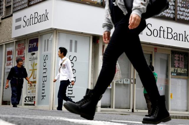 people walk past a retail shop of the softbank telecommunications company in tokyo japan may 10 2016 photo reuters