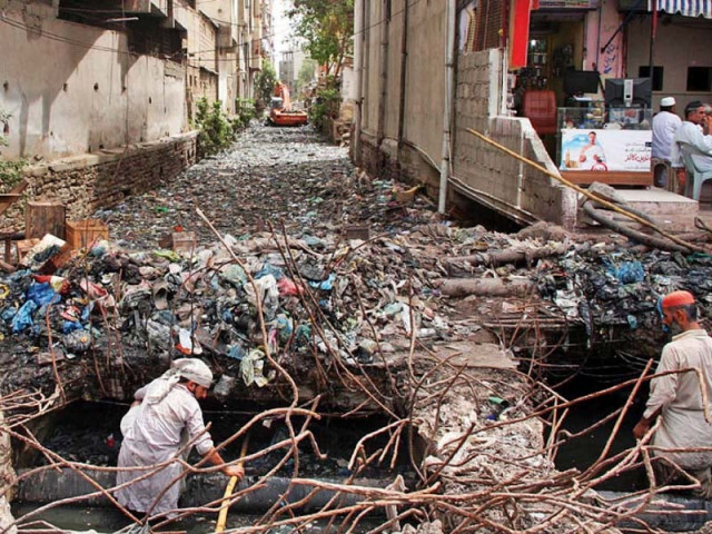 workers cleaning a nullah in lee market photo online