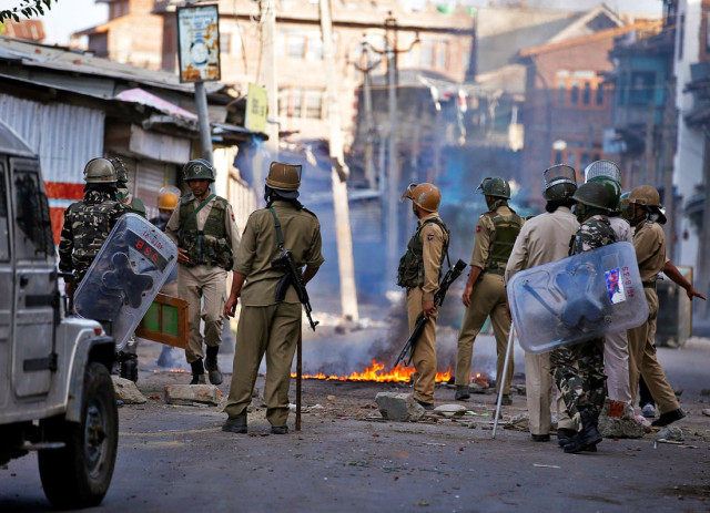 indian policemen stand next to a burning handcart set on fire by demonstrators during a protest in srinagar against the recent killings in kashmir july 18 2016 photo reuters