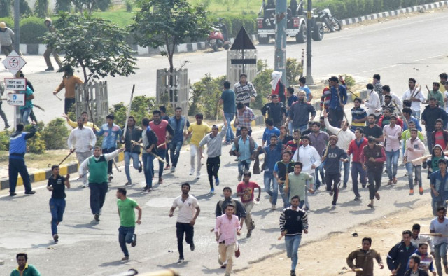 protesters run along a street during violent clashes with rival caste groups over access to jobs and education in rohtak northern india on february 19 2016 photo afp protesters run along a street during violent clashes with rival caste groups over access to jobs and education in rohtak northern india on february 19 2016 photo afp