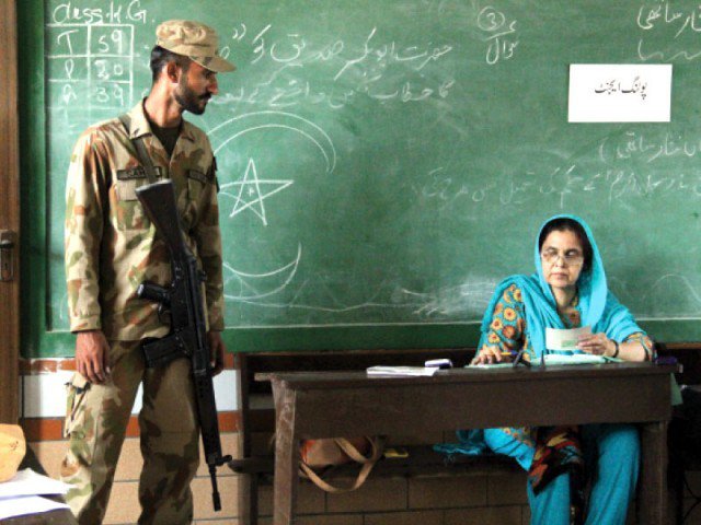 in this file photo a pakistan army soldier stands guard as a presiding officer in na 254 korangi karachi photo express