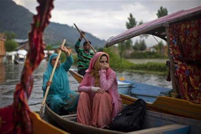 a woman travels in a boat in the waters of dal lake in srinagar in indian held kashmir photo reuters