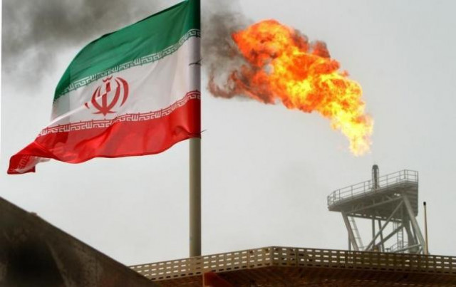 gas flares from an oil production platform at the soroush oil fields with an iranian flag in the foreground in the persian gulf photo reuters