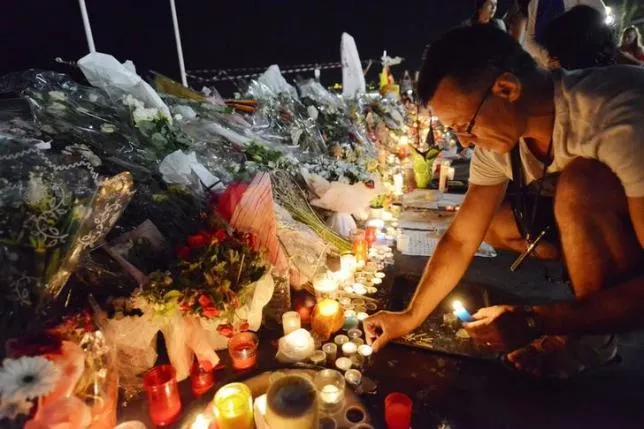 a man places candles near flowers that were left in tribute at makeshift memorials to the victims of the truck attack along the promenade des anglais in nice france photo reuters a man places candles near flowers that were left in tribute at makeshift memorials to the victims of the truck attack along the promenade des anglais in nice france photo reuters