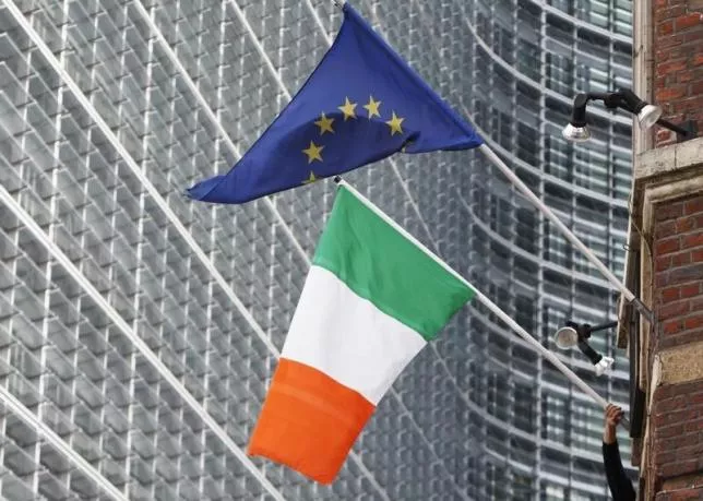 a man adjusts an irish flag as it flies next to a european union flag near the eu commission headquarters in brussels photo reuters a man adjusts an irish flag as it flies next to a european union flag near the eu commission headquarters in brussels photo reuters