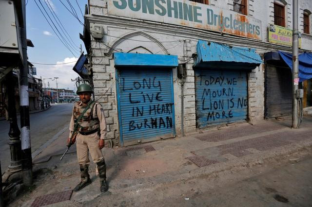 an indian policeman stands guard in front of closed shops painted with graffiti during a curfew in srinagar july 12 2016 photo reuters an indian policeman stands guard in front of closed shops painted with graffiti during a curfew in srinagar july 12 2016 photo reuters