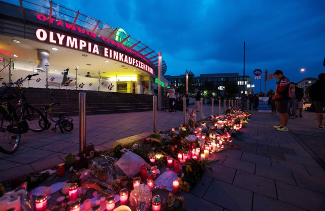 candles and flowers lie in front of the olympia einkaufszentrum shopping centre on july 23 2016 in munich southern germany one day after a teenage german iranian gunman killed nine people and wounded 16 photo afp candles and flowers lie in front of the olympia einkaufszentrum shopping centre on july 23 2016 in munich southern germany one day after a teenage german iranian gunman killed nine people and wounded 16 photo afp