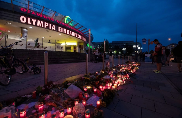candles and flowers lie in front of the olympia einkaufszentrum shopping centre photo afp candles and flowers lie in front of the olympia einkaufszentrum shopping centre photo afp