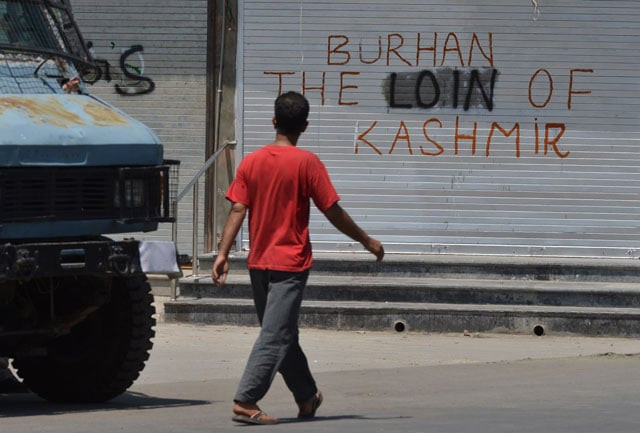 a kashmiri muslim walks near graffiti during a curfew in downtown srinagar on july 24 2016 photo afp a kashmiri muslim walks near graffiti during a curfew in downtown srinagar on july 24 2016 photo afp