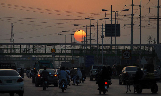 traffic moves along on peshawar road as the sun sets in rawalpindi photo online