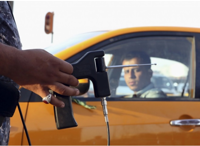 an iraqi policeman uses a hand held device that is supposed to detect bombs at a checkpoint in basra photo afp