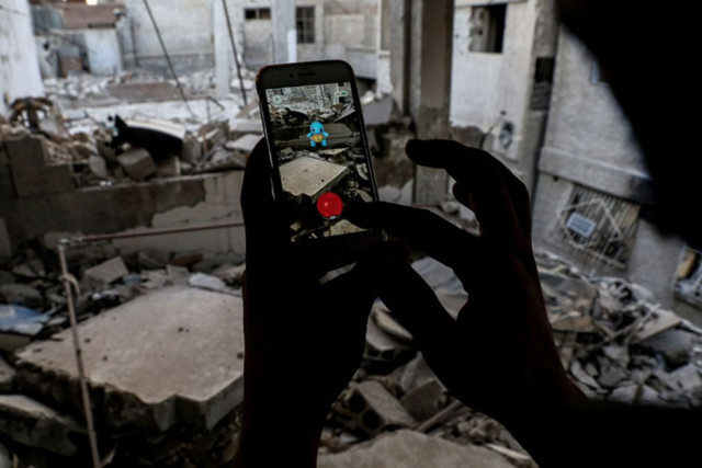 a syrian gamer uses the pokemon go application on his mobile to catch a pokemon amidst the rubble in the besieged rebel controlled town of douma a flashpoint east of the capital damascus on july 23 2016 photo afp a syrian gamer uses the pokemon go application on his mobile to catch a pokemon amidst the rubble in the besieged rebel controlled town of douma a flashpoint east of the capital damascus on july 23 2016 photo afp