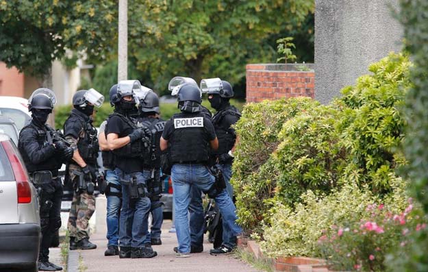 french policemen stand in a street during the search of a house in the normandy village of saint etienne du rouvray on july 26 2016 following the church attack photo afp