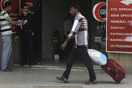 a foreign worker pulls his luggage along a street in riyadh photo reuters