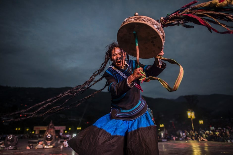 a shaman dressed with the traditional yi costume performs at the torch festival as a result of fast urbanisation in the rural area of china like lienchang prefecture the traditional costume is fading away for the yi people in daily life photo afp