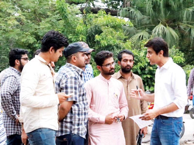 activists of the justice project pakistan jpp speak to the passers by l posters prepared for the campaign to highlight the threat to fundamental rights from abuse of terrorism laws photo express