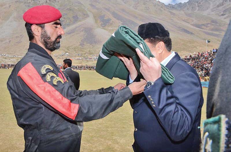 coas kisses the national flag presented by the paratroopers at the shandur polo festival in chitral photo inp