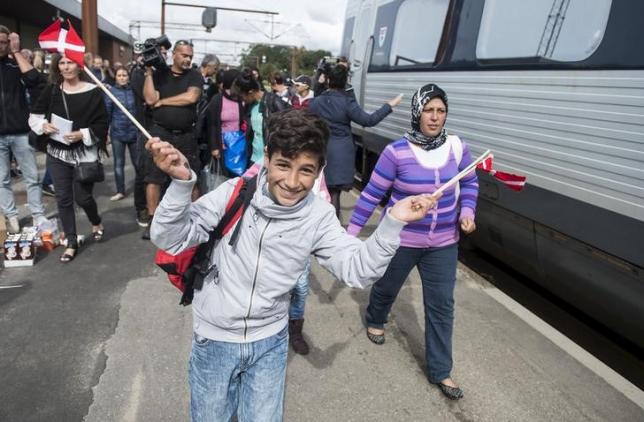 a boy waves danish flags as he joins fellow migrants mainly from syria photo reuters