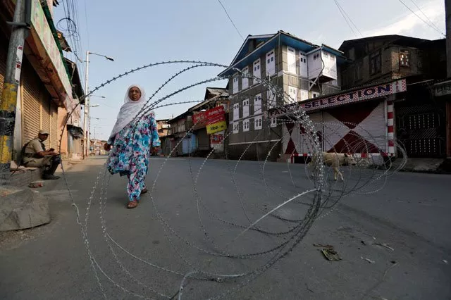 a kashmiri woman walks behind concertina wire during a curfew in downtown held srinagar august 1 2016 photo reuters a kashmiri woman walks behind concertina wire during a curfew in downtown held srinagar august 1 2016 photo reuters
