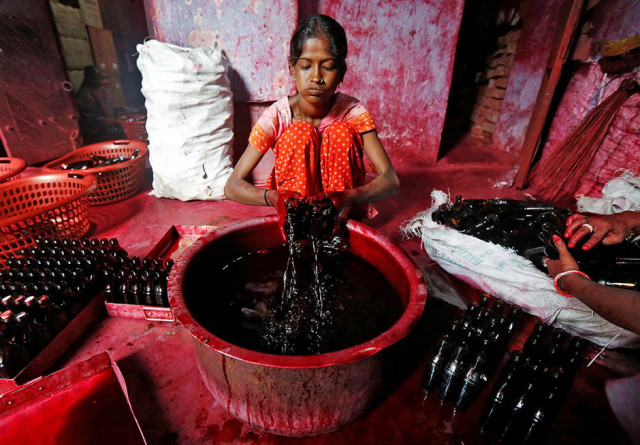 a worker fills bottles with alta a red dye which hindu women apply with cotton on the border of their feet during marriages and religious festivals at a workshop in kolkata india photo reuters