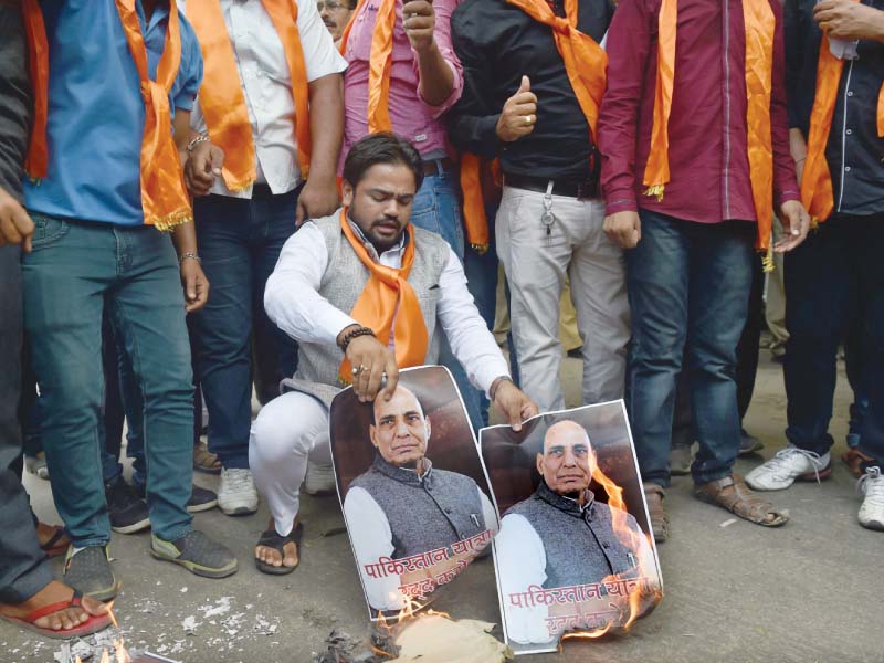 shiv sena activists burn a poster of indian home minister rajnath singh in new delhi to protest his scheduled visit to pakistan photo afp