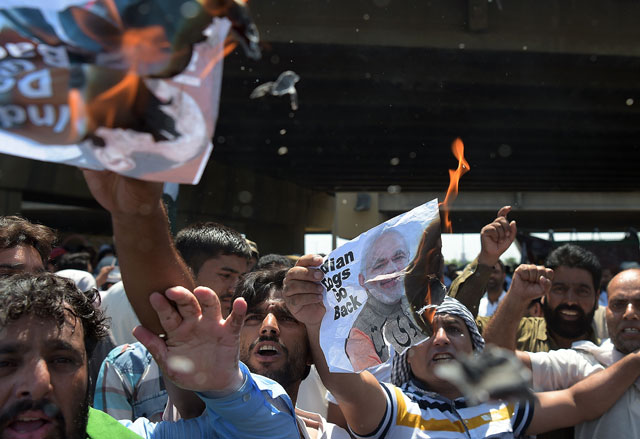 kashmiri protesters hold burning posters bearing the images of indian prime minister narendra modi and indian home minister rajnath singh as they block a main highway ahead of the arrival of indian home minister rajnath singh in islamabad on august 3 2016 photo afp