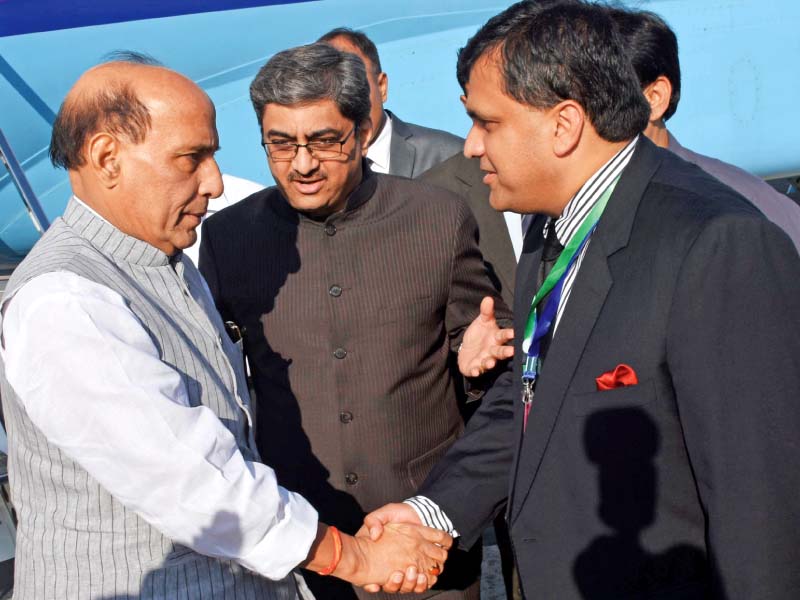 a senior pakistani official greets indian home minister rajnath singh photo afp
