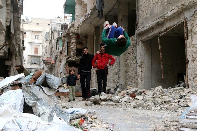 ahmad al sawas performs gymnastic moves near damaged buildings in the rebel held bustan al qasr neighbourhood of aleppo syria march 26 2016 photo reuters