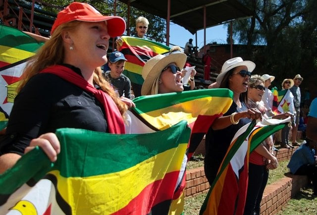 zimbabwe 039 s supporters sing the national anthem during the first day of the second test in a series of two matches where new zealand leads hosts zimbabwe 1 0 at the queens sports club in bulawayo on august 6 2016 photo afp