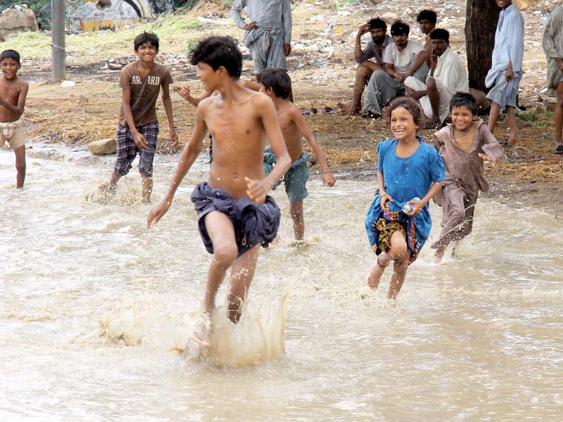 children enjoy a spontaneous game in a pool of water by the roadside in karachi the met office recorded the highest rainfall of 55mm at sharae faisal photo athar khan express