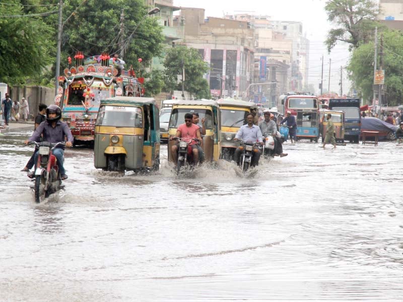 commuters drive through rainwater after a heavy downpour in the saddar area of karachi on saturday photo athar khan